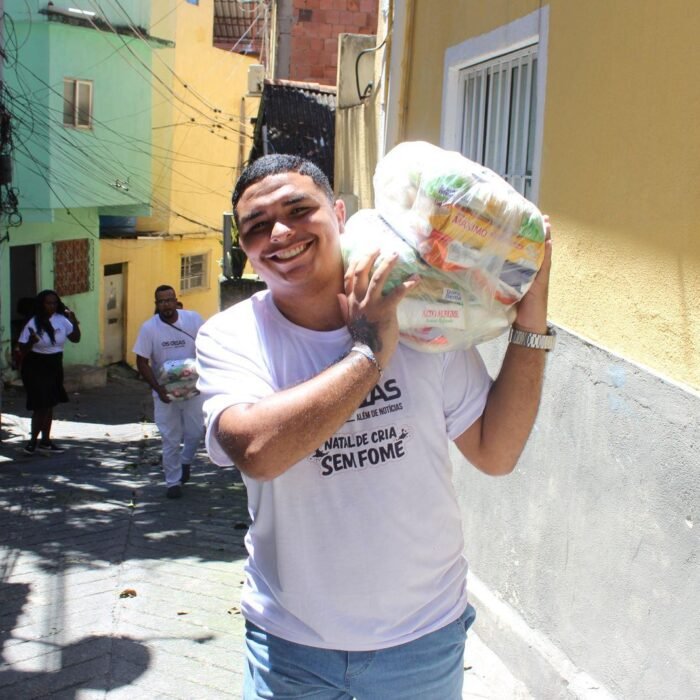 Ryan Mazcatti carrega uma cesta de alimentos em uma viela