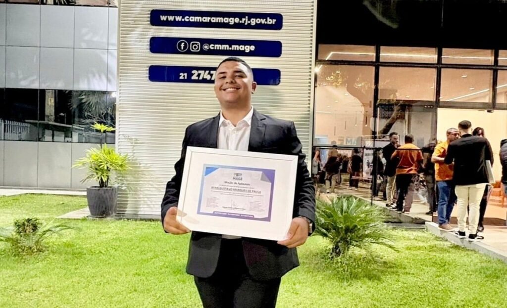 Ryan Mazcatti segura um certificado emoldurado